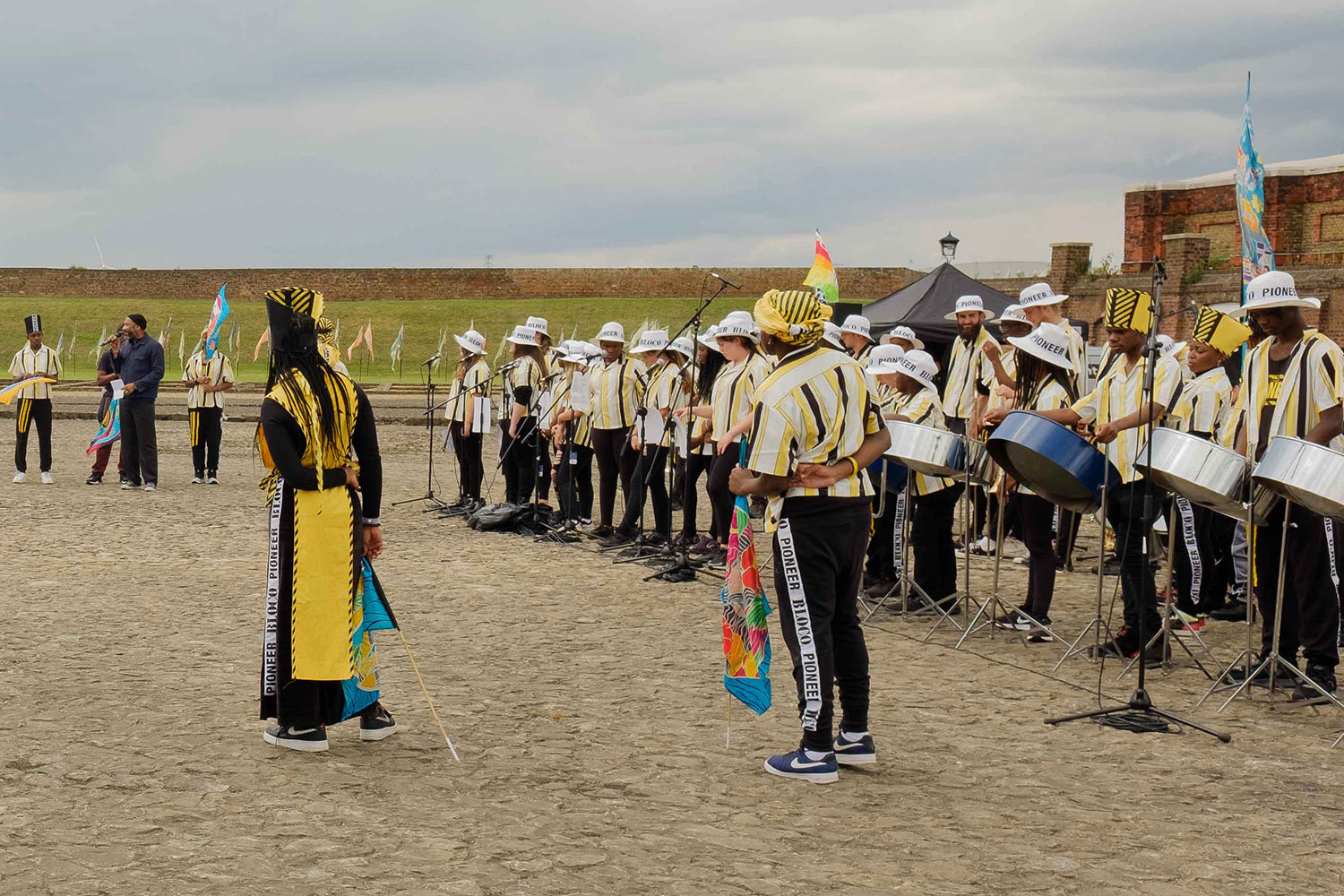 Very wide shot of Tilbury Fort interior showing Kinetika bloco preparing to play for the gathered crowd
