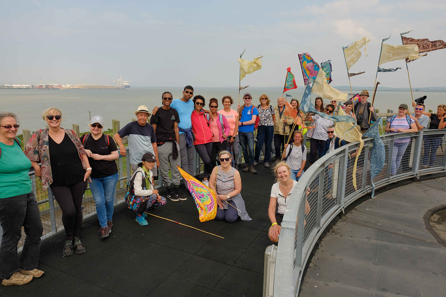 A large group of people smile at the camera from the top of the Thameside Nature reserve visitor centre