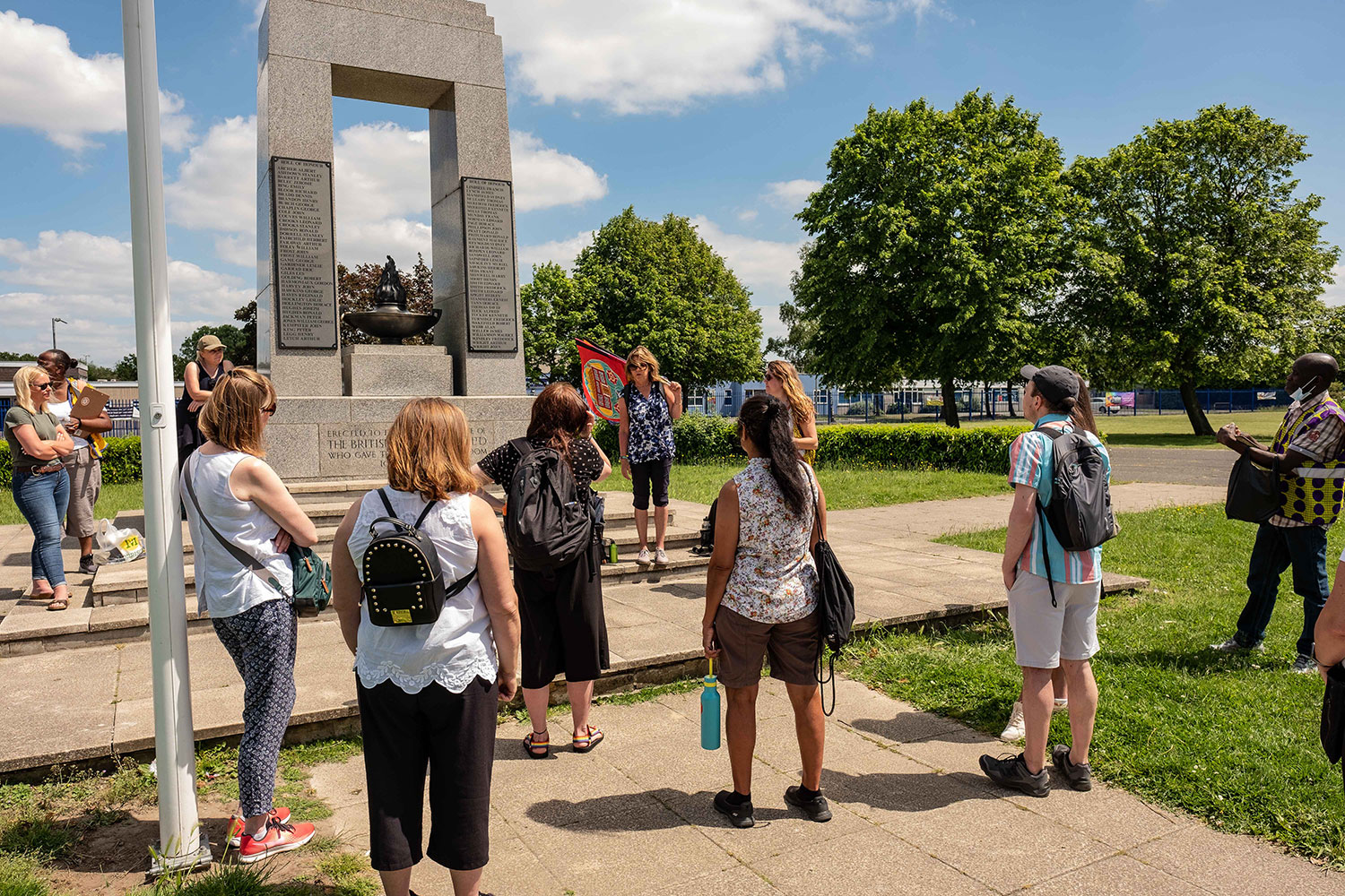 Walkers stop at the large stone Bata war memorial to listen to Ali Pretty