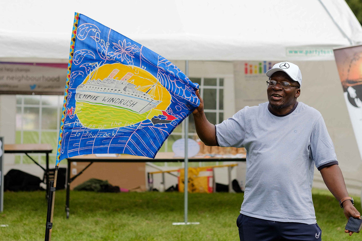 An illustrated flag depicting HMS Windrush is stretched out so the design is clearly visible