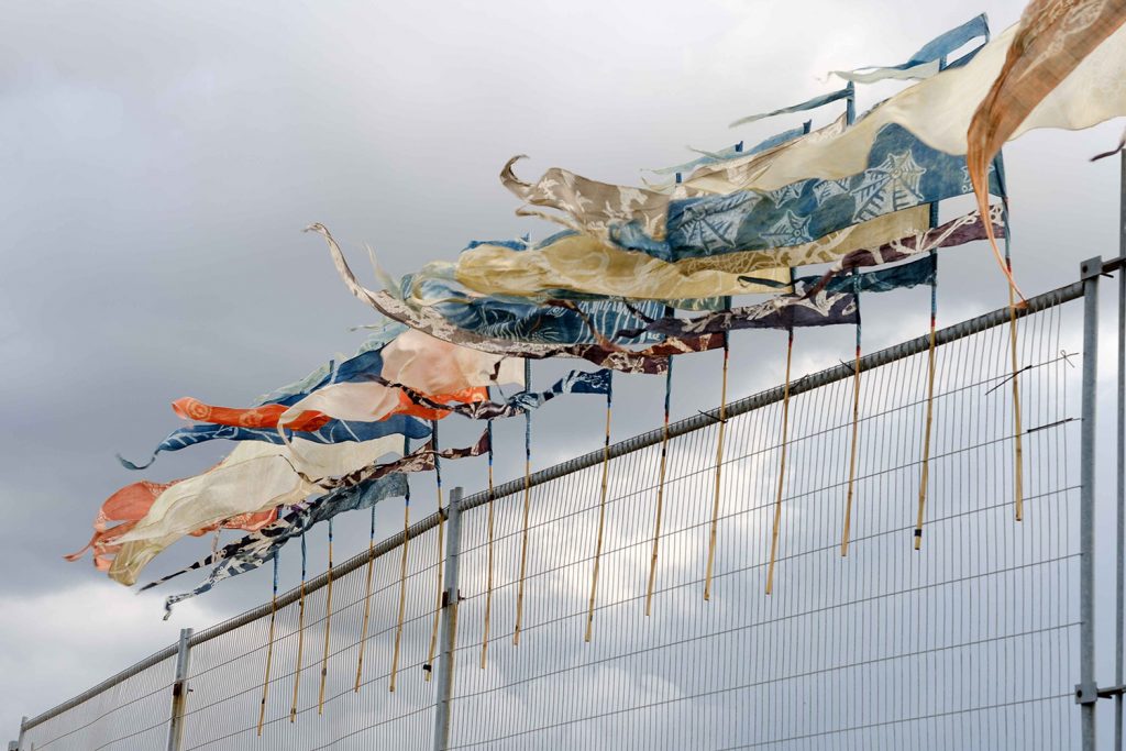 Beach of Dreams silk pennants displayed on top of herras fencing