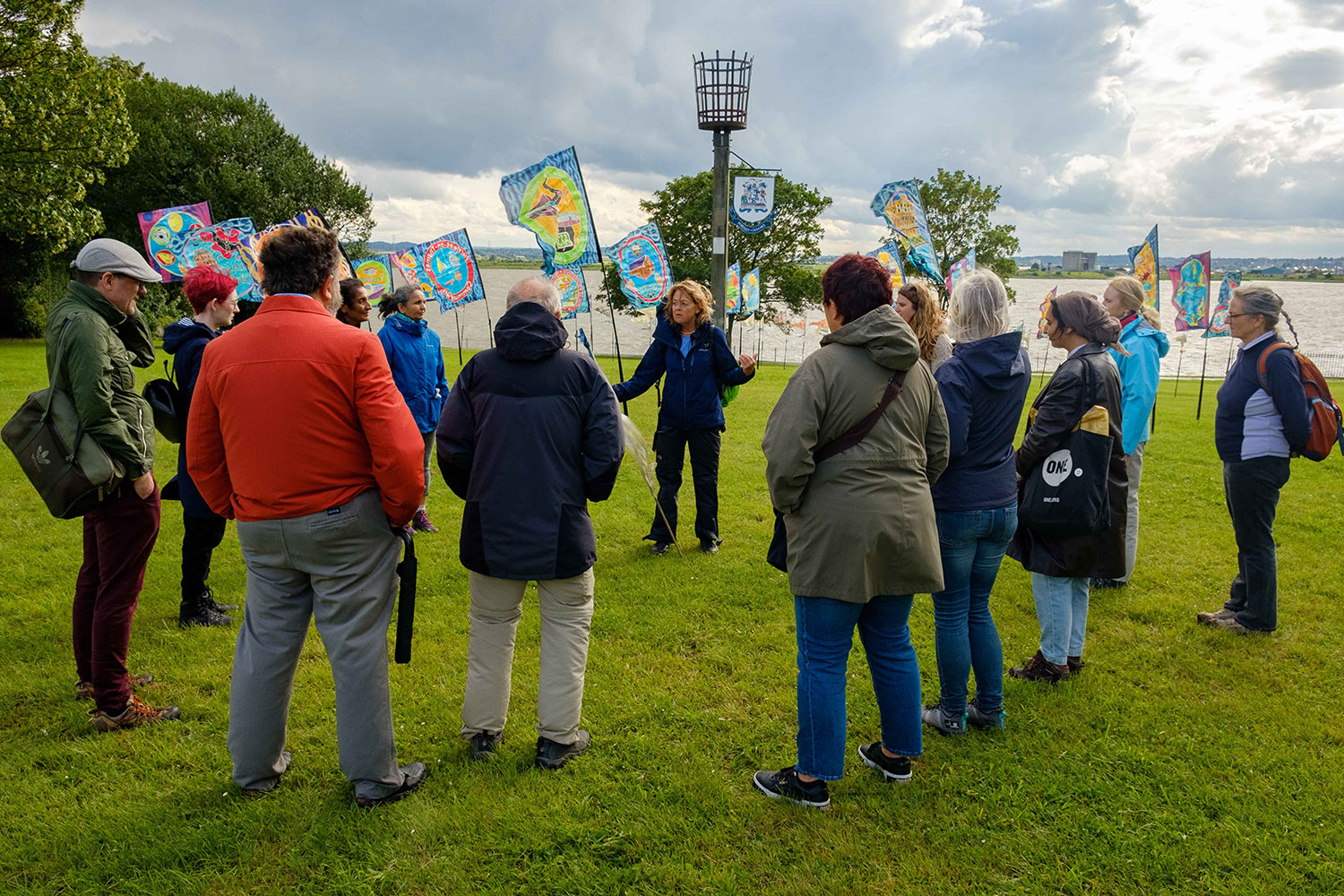 Ali Pretty speaks to a circle of people gathered on the grass in front of the Purfleet-on-Thames Beacon