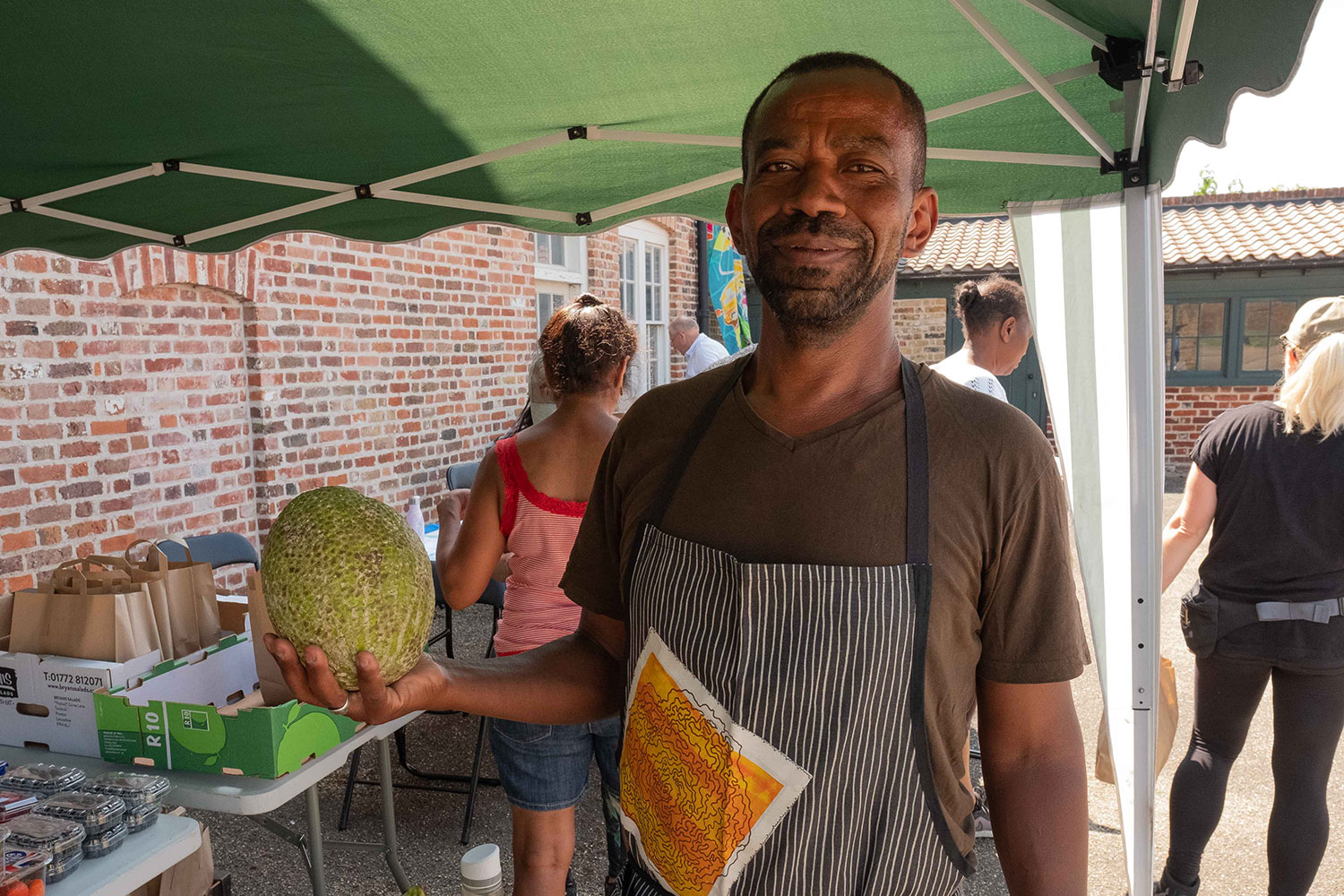 Zyle Mills holds a breadfruit from his Heavenly Greens fruit and veg stall