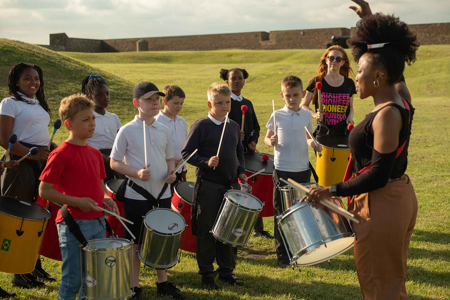 Young musicians play samba drums with Kinetika Bloco at Tilbury Fort